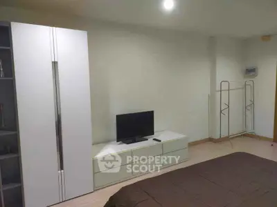 Modern bedroom with sleek wardrobe and TV unit in minimalist design.