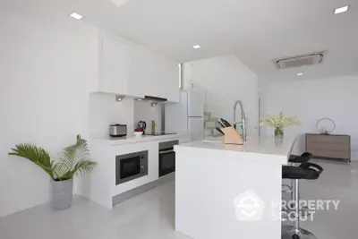 Modern white kitchen with sleek design and open layout