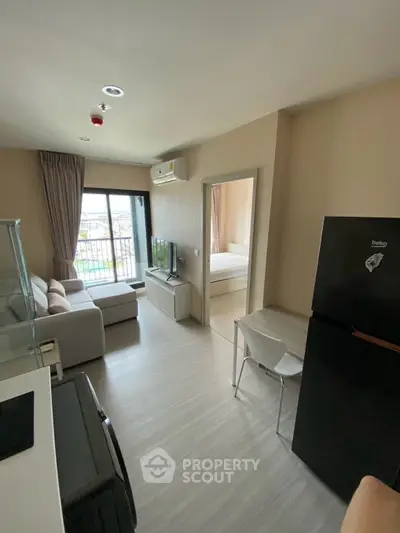 Modern apartment interior with open layout, featuring a cozy living room and a view of the balcony.