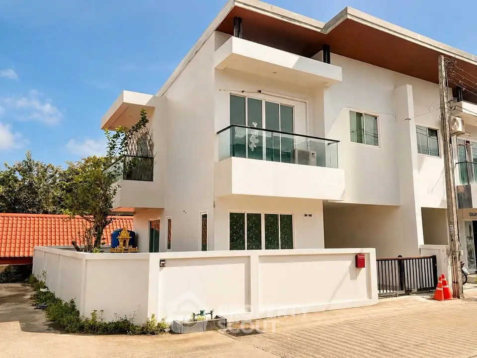 Modern two-story white building with balconies and a sleek exterior design, perfect for contemporary living.
