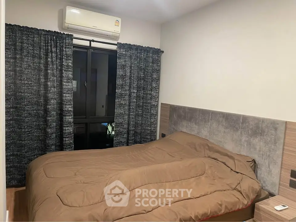 Cozy bedroom with modern decor and air conditioning, featuring a comfortable bed and stylish curtains.