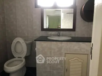 Cozy bathroom with modern fixtures and neutral tiles, featuring a sleek vanity and large mirror.