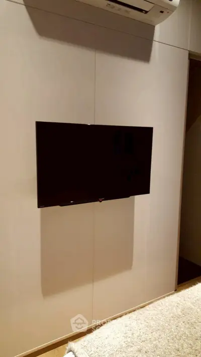 Modern living room with wall-mounted TV and sleek air conditioning unit.