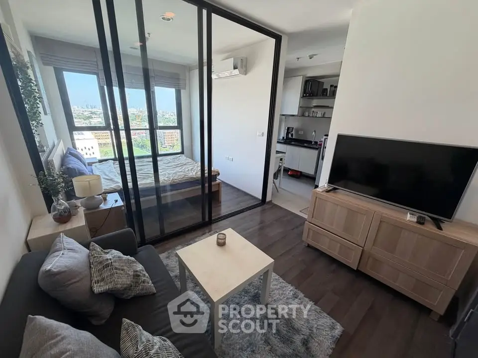 Modern studio apartment with glass partition, cozy living area, and city view.