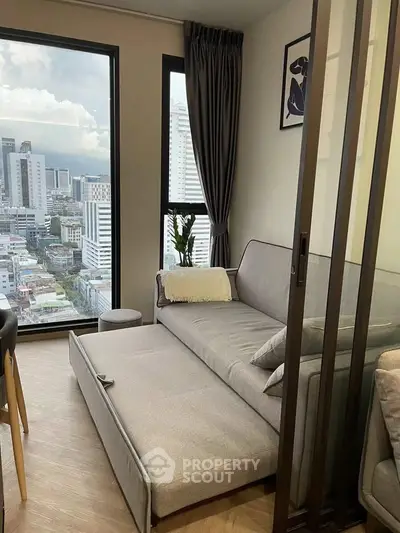 Modern living room with city view and stylish furniture in high-rise apartment.