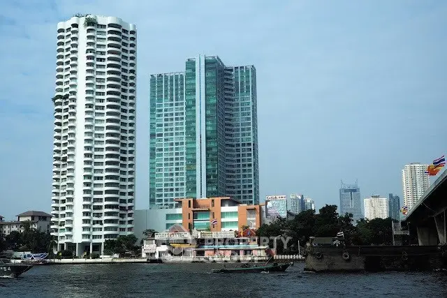 Stunning riverside view of modern high-rise buildings in a bustling cityscape.