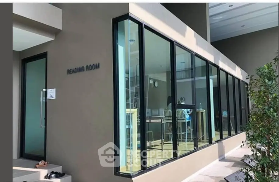Modern reading room with large glass windows and stylish interior design.