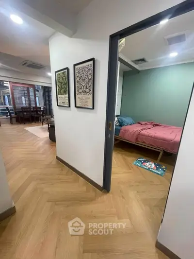 Modern apartment interior with stylish bedroom and open living area, featuring elegant wood flooring and contemporary decor.