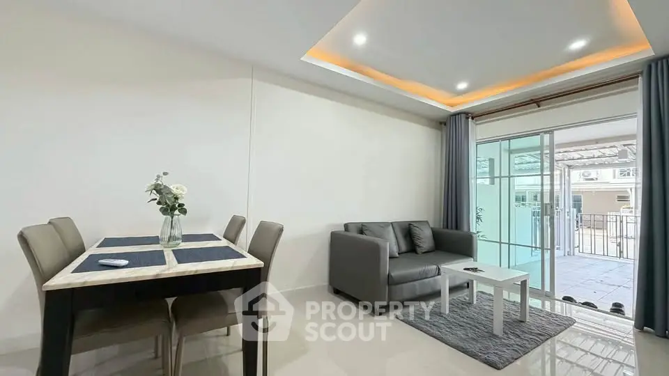 Modern living room with sleek furniture and balcony access in a stylish apartment.