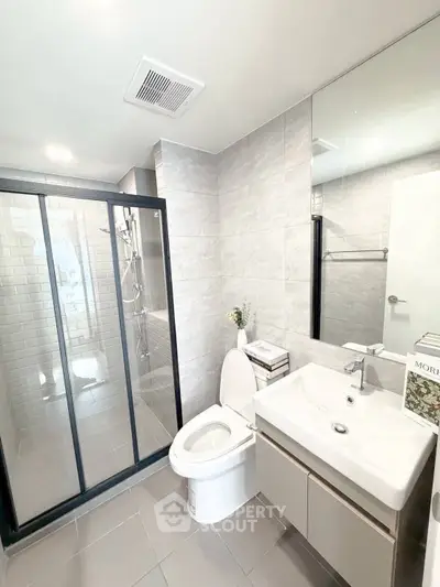 Modern bathroom with sleek shower and elegant fixtures in a contemporary home.