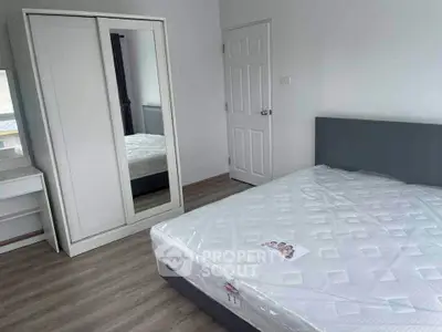 Modern bedroom with sleek wardrobe and comfortable bed in minimalist design.
