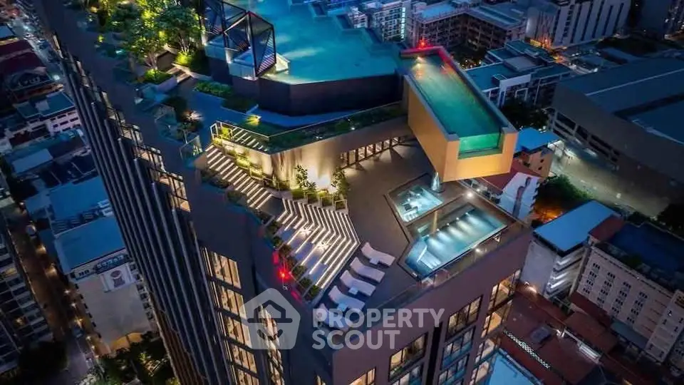 Stunning rooftop pool and terrace with panoramic city views at night.