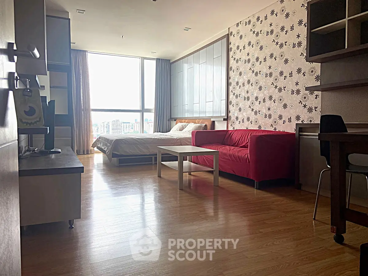 Spacious studio apartment with modern decor and large window view