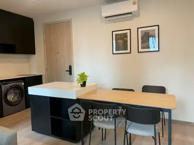 Modern kitchen with sleek design, featuring a washing machine and stylish dining area.
