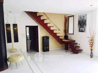 Modern interior with stylish staircase and elegant decor in a spacious living area.