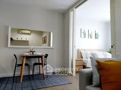 Modern open-plan living room with dining area and cozy bedroom in stylish apartment.