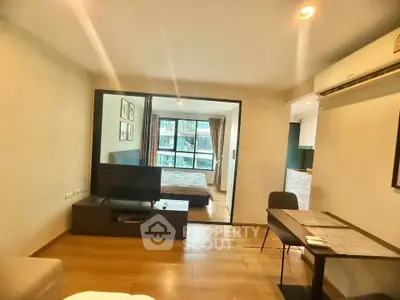 Modern apartment with open living room and bedroom layout, featuring sleek furniture and natural light.