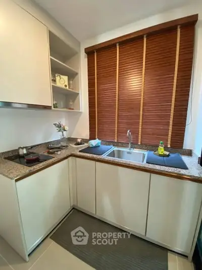 Modern kitchen with granite countertops and wooden blinds