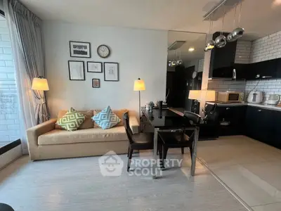 Modern living room with cozy sofa, dining area, and sleek kitchen in open layout.