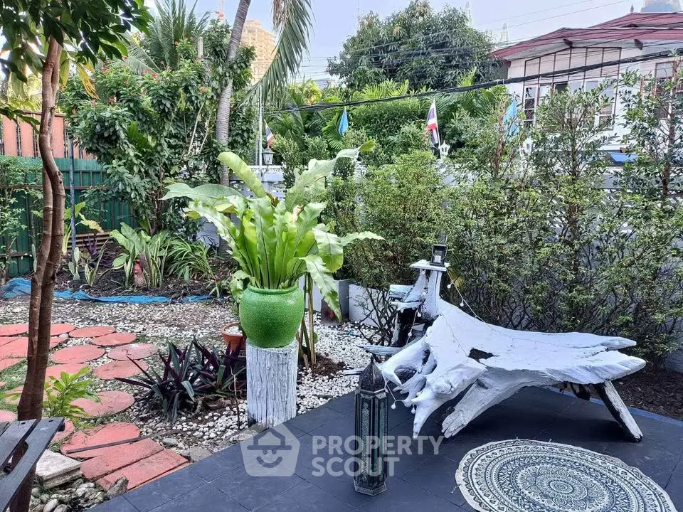 Charming garden oasis with lush greenery and unique seating area, perfect for relaxation and outdoor enjoyment.