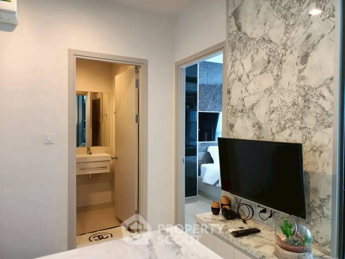 Modern apartment interior with marble accents and sleek TV setup