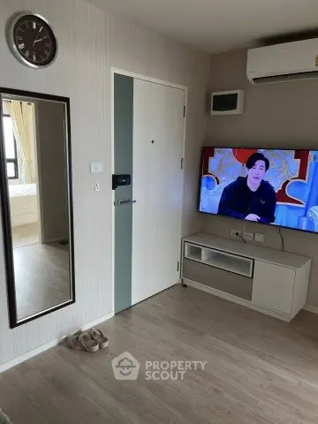 Modern living room with wall-mounted TV and air conditioning in a stylish apartment.