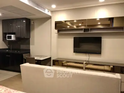 Modern living room with sleek kitchen and wall-mounted TV, perfect for urban living.