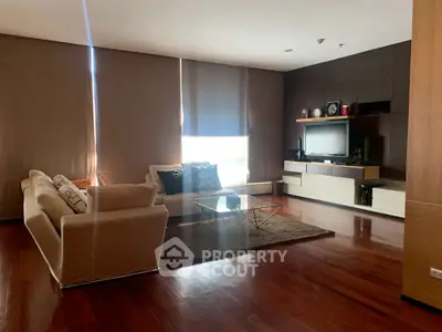 Spacious modern living room with elegant wooden flooring and stylish furniture