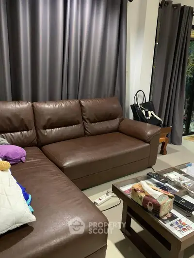 Cozy living room with brown leather sofa and modern decor, perfect for relaxation.