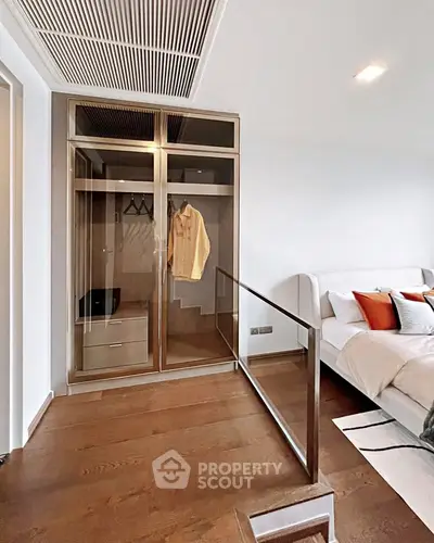 Modern bedroom with stylish glass wardrobe and cozy bed setup