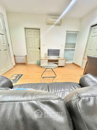 Cozy living room with leather sofa and modern decor, perfect for relaxation and entertainment.