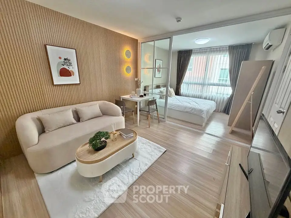 Modern open-plan living room and bedroom with stylish decor and natural light.