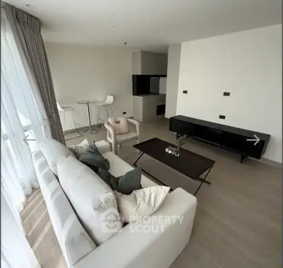 Modern living room with stylish furniture and large windows offering natural light.