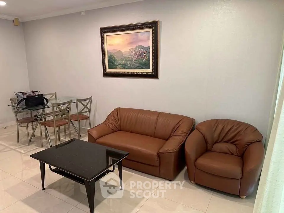 Cozy living room with leather sofa set and elegant dining area, perfect for modern living.