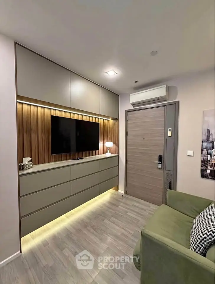 Modern living room with sleek cabinetry and wall-mounted TV, featuring ambient lighting and stylish decor.