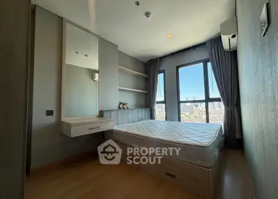 Modern bedroom with city view, featuring large windows and stylish furnishings.