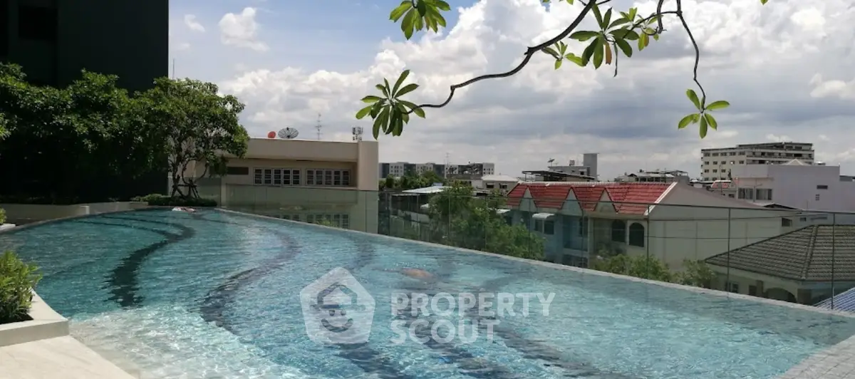 Stunning rooftop infinity pool with panoramic city views and lush greenery.