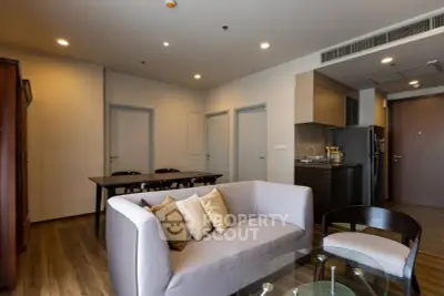 Modern living room with cozy sofa and dining area in open layout apartment.