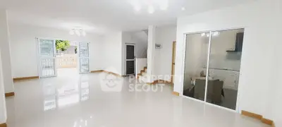 Spacious open-plan living area with large windows and bright natural light