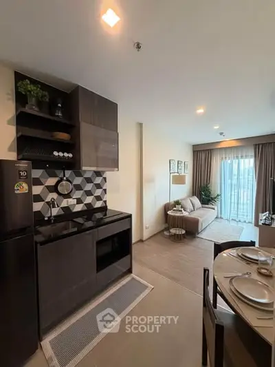 Modern open-layout kitchen and living room with stylish decor and natural light.