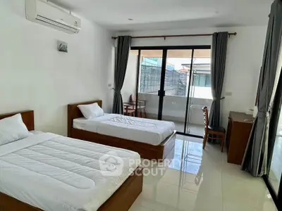 Spacious twin bedroom with balcony access and modern furnishings