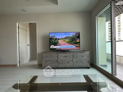 Modern living room with TV and balcony access in a stylish apartment.