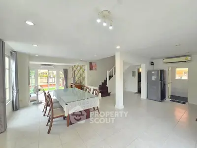 Spacious open-plan living and dining area with modern kitchen and large windows.