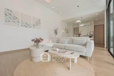 Elegant living room with modern decor and natural light, featuring a cozy sofa and stylish coffee table.