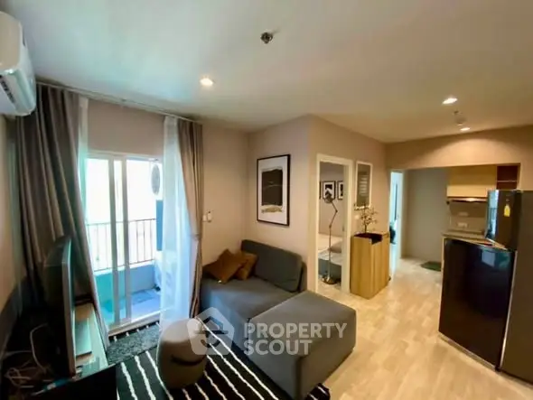 Modern living room with cozy sofa, stylish decor, and open kitchen layout in a bright apartment.