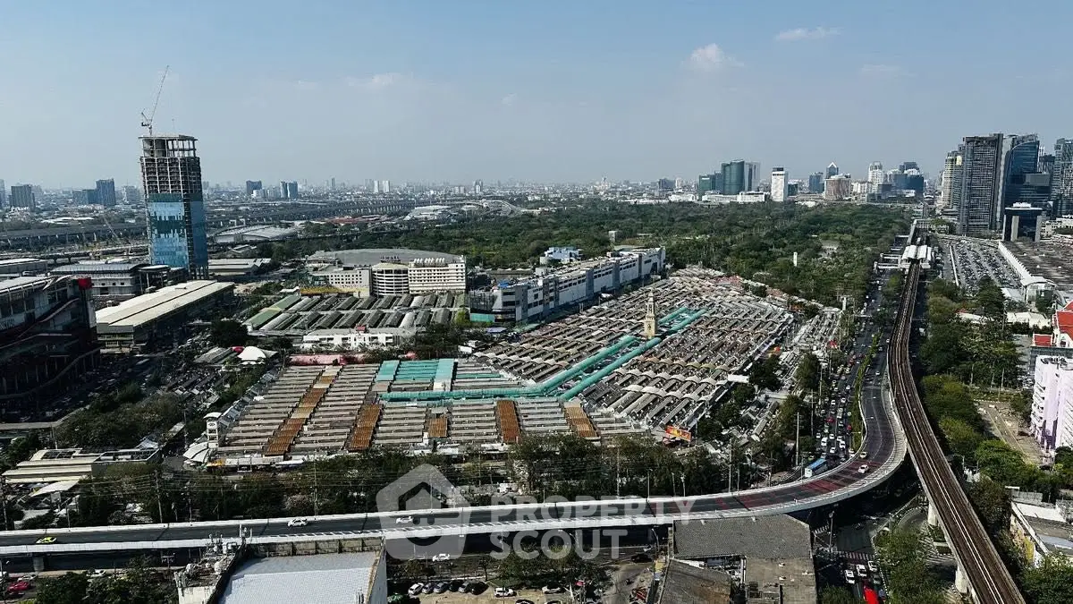 Aerial view of urban landscape with mixed-use buildings and green spaces, showcasing city development.
