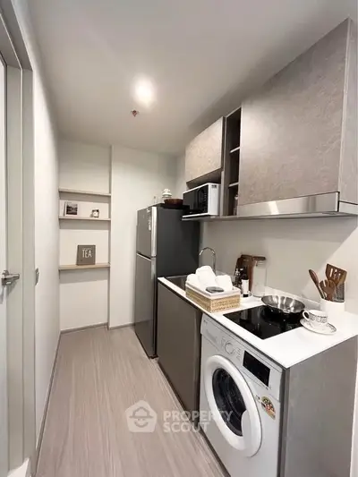 Modern kitchen with sleek appliances and compact design, featuring a washing machine and ample storage.
