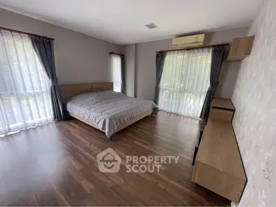 Spacious bedroom with large windows and modern decor