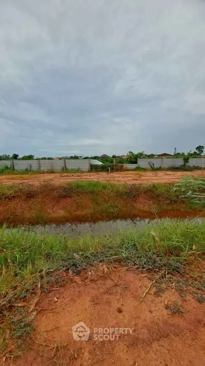 Expansive plot of land with potential for development, featuring lush greenery and a serene environment.