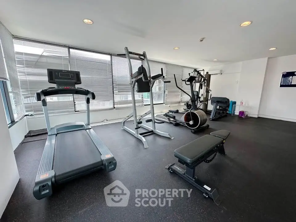Modern gym with state-of-the-art equipment and large windows for natural light.